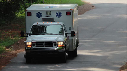 Ambulance driving down a road