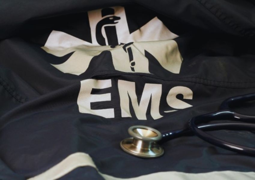 EMS logo seen on the back of a jacket with a stethoscope laying on it. 